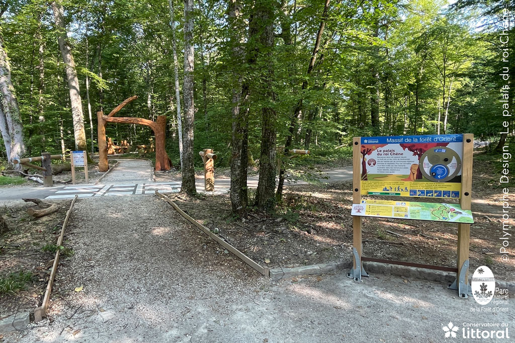 Photo du d&eacute;part du sentier, avec un panneau d'information multisensoriel.